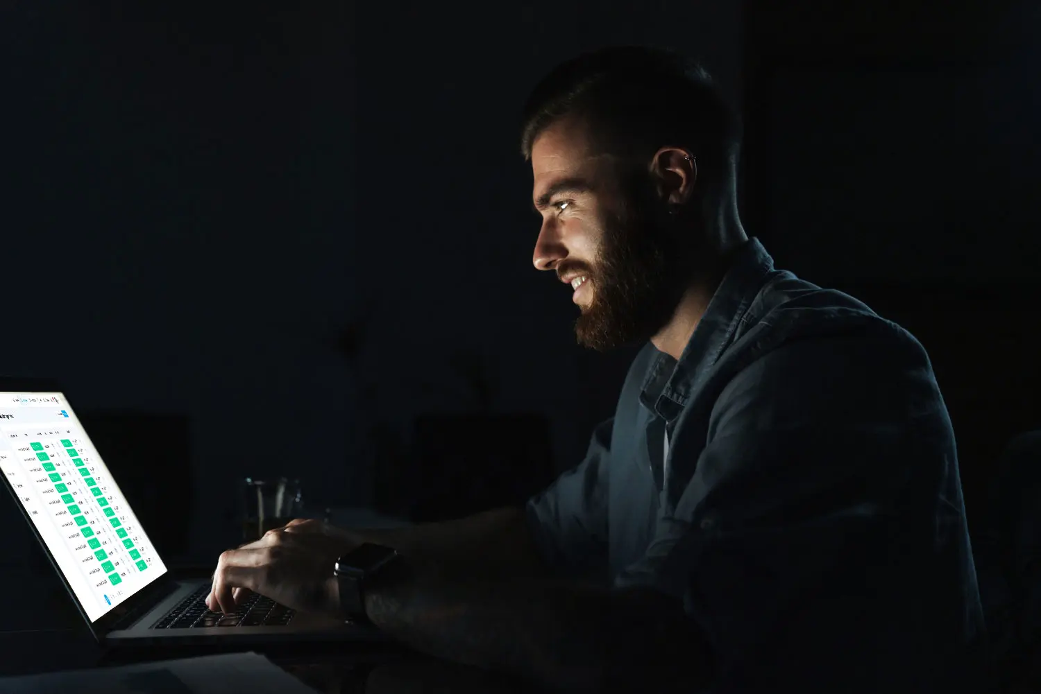accounts-page-confident-smiling-young-man-working-laptop-computer-while-sitting-table-indoors-night